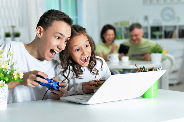 boy and girl playing video game on laptop - Photo, Image