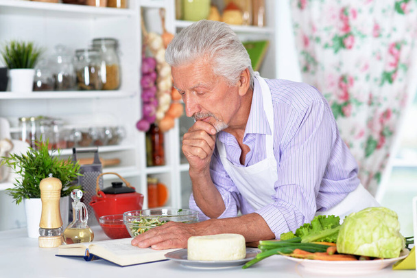 elderly  making salad  at kitchen - Фото, изображение