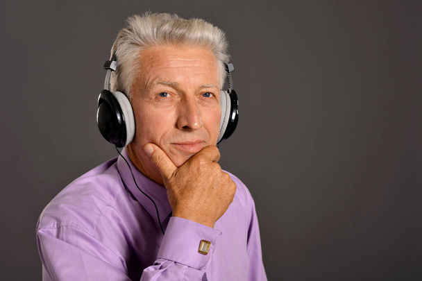 Senior man listening to  music in headphones - Foto, afbeelding