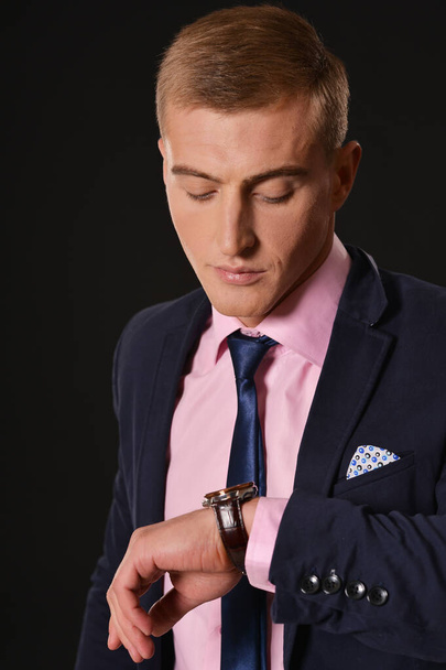 Portrait of young businessman checking time  on watch  - Fotografie, Obrázek