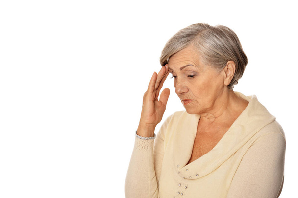  serious senior woman  with headache,  isolated on white - Zdjęcie, obraz