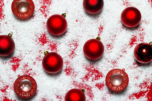Bolas rojas de Navidad y nieve blanca sobre fondo rojo. Puesta plana
. - Foto, imagen