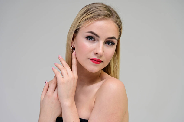 Concept cosmetically, skin rejuvenation. Close-up portrait of a beautiful blonde model on a white background with long hair, excellent makeup, beautiful face and lips. - Photo, image
