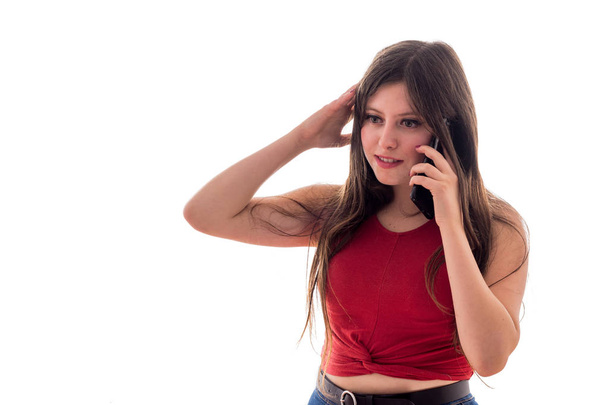 Καυκάσια νεαρή κοπέλα μιλάει με κινητό τηλέφωνο σε λευκό φόντο απομονωμένη - Φωτογραφία, εικόνα