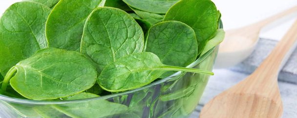Spinach in a glass bowl with cooking spoon - Photo, Image