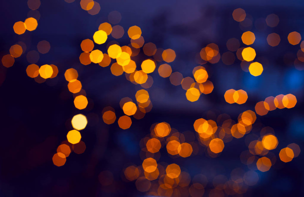 抽象的な焦点を当てた輝く背景。夜の黄金の光のぼやけたボケ。クリスマスとホリデーのコンセプト - 写真・画像
