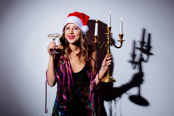 Beautiful woman in Christmas hat with candlestick and champagne  - Foto, immagini