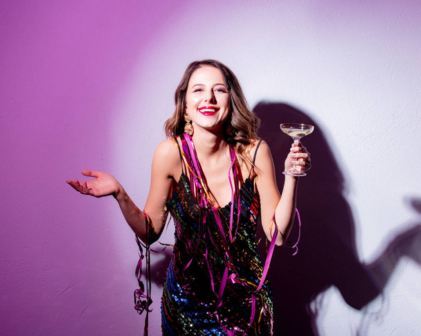 Mooie vrouw met serpentijn en champagne in een nieuwjaar tijd - Foto, afbeelding