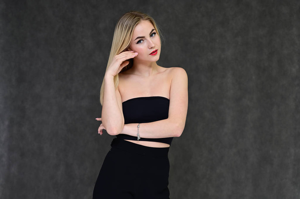 Fashion glamor concept with girl secretary. Portrait of a fashionable beautiful blonde model with long hair, great makeup, on a gray background. - 写真・画像