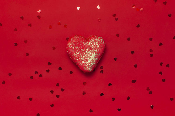 herzförmige Makronenkuchen und Konfetti auf rotem Hintergrund lagen flach. Kreative Komposition für Valentinstag, Liebeskonzept, Geburtstagsgeschenk, Muttertag, Urlaubshintergrund. Liebe zu Süßigkeiten - Foto, Bild
