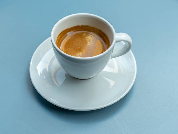 ένα φλιτζάνι καφέ σε ένα μπλε γραφείο - Φωτογραφία, εικόνα