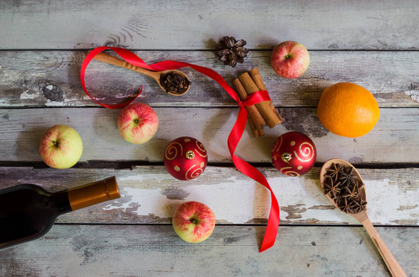 Ингредиенты рецепта глинтвейна, красные рождественские шары и сосновый конус на старом деревянном столе
. - Фото, изображение