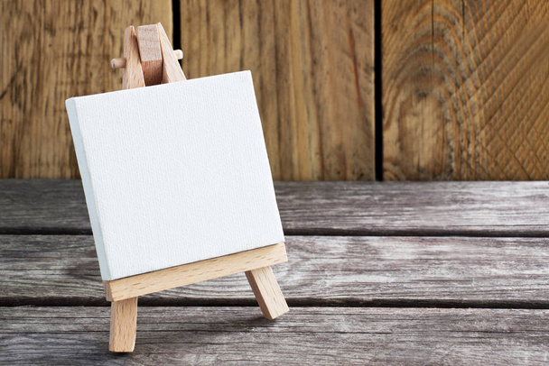 Easel on wooden background with copy space - Foto, afbeelding