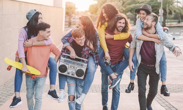 Glückliche Freunde spazieren huckepack durch die Innenstadt - Jugendliche lachen und verbringen Zeit gemeinsam im Freien - Jugendkultur - Foto, Bild