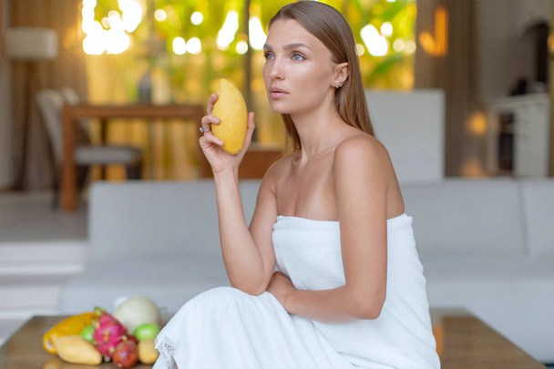 junges schönes Mädchen mit frischer Mango. frisches Obst zum Frühstück - Foto, Bild