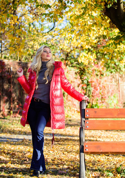Jacket for fall season concept. Woman fashionable blonde with makeup stand in autumnal park. Girl wear red bright warm jacket. Fall fashion concept. Lady attractive fashionista posing in jacket - Foto, Imagen
