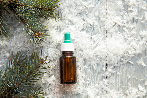 fenyő aroma olaj kivonat természetes kozmetikai üveg aromaterápia téli havas háttér - Fotó, kép