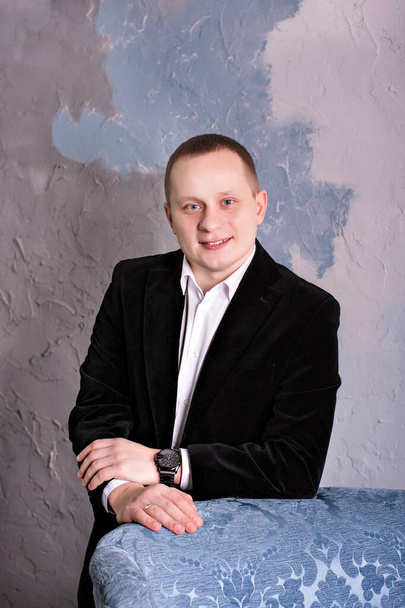 close portrait young attractive man in suit near armchair - Zdjęcie, obraz