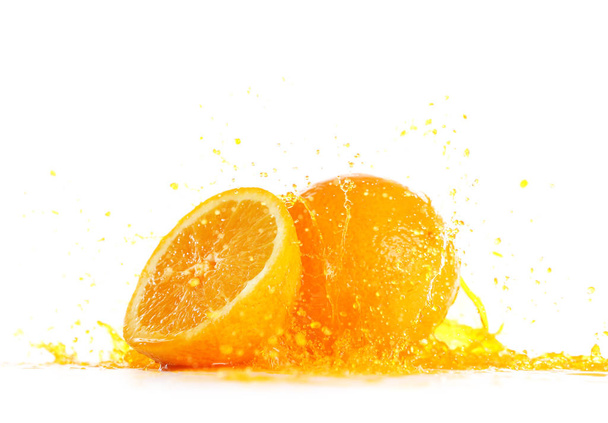 Ripe oranges and splash of juice on white background - Photo, Image