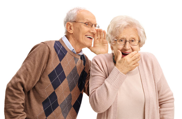 Elderly man whispering to a surprised elderly woman - Photo, Image