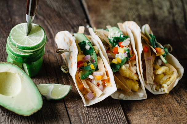 Snídaně tacos s vejci, avokádem a čerstvě nakrájenou zeleninou - Fotografie, Obrázek