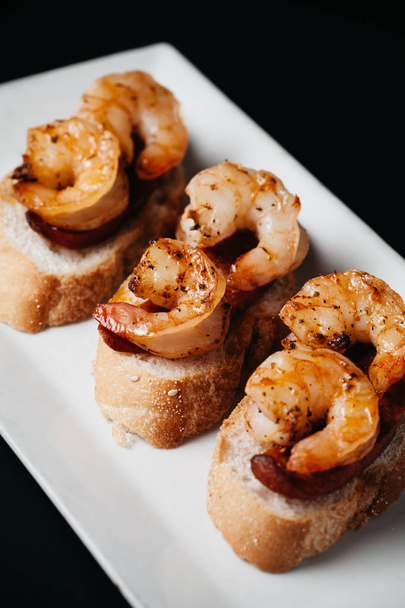 Plate of delicious  bruschetta with grilled shrimp and sausage o - Foto, Imagen