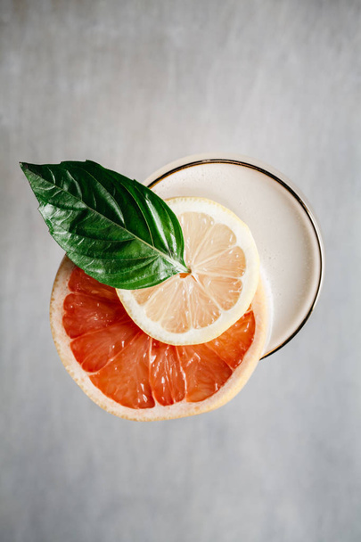 Cocktail alcoolisé d'été garni d'orange sanguine et de basilic
 - Photo, image