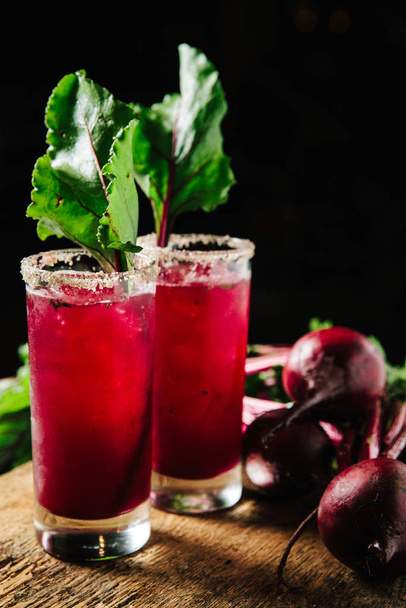 Red beet juice and gin cocktail on rustic background - Photo, Image