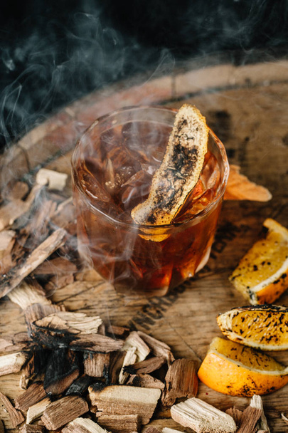 Smoked old fashioned cocktail on dark wooden background - Foto, Imagem