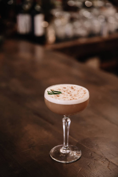A creamy coffee cocktail with a bar in the background  - Foto, Bild