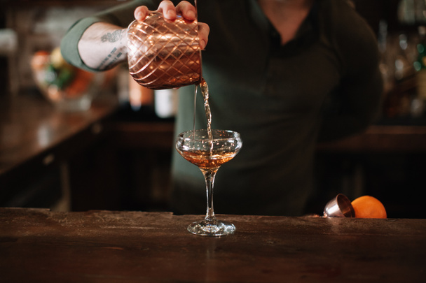 Un barista versa un cocktail in un bicchiere
  - Foto, immagini