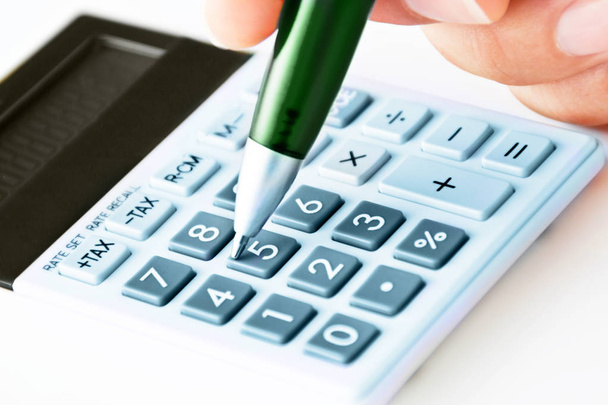 Calculatrice de poche avec stylo main et stylo bille vert close-up bac
 - Photo, image