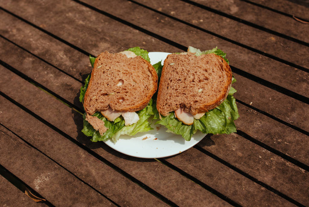 Sandwich with Hum and salad on a wooden bench - Foto, Bild