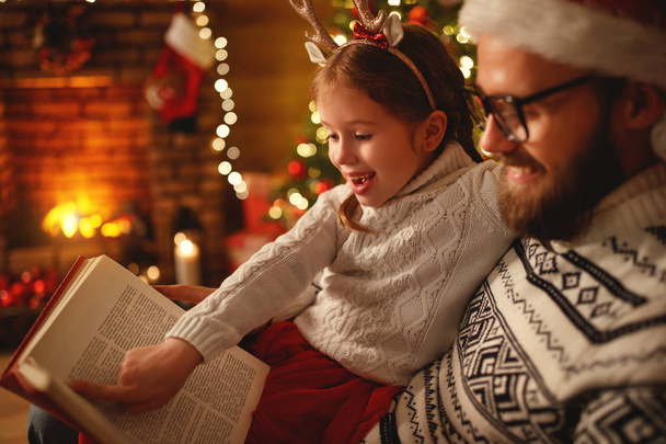 Štědrý večer. rodinný otec a dítě čtení magické knihy v Hom - Fotografie, Obrázek
