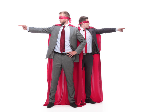 two businessmen in superhero raincoats pointing in different directions. - Foto, afbeelding