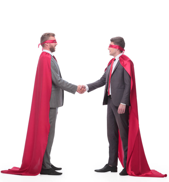 two businessman in superhero capes shake hands - Foto, Bild