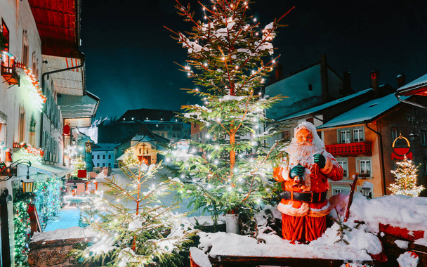 Άγιος Βασίλης και χριστουγεννιάτικο δέντρο σε Gruyeres χειμώνα νύχτα νέα - Φωτογραφία, εικόνα