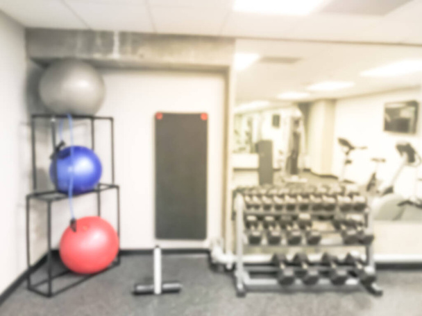 Размытый фон красочный медицинский мяч и гантель в современном фитнес-центре в США
 - Фото, изображение