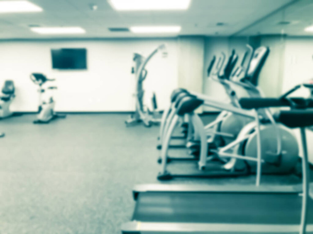 Rozmyta bieżnia tła, eliptyczne, trenażery i urządzenia treningowe w nowoczesnym centrum fitness w Usa - Zdjęcie, obraz