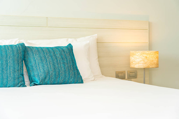 Almohada y manta en la cama con lámpara de luz decoración interior
 - Foto, imagen