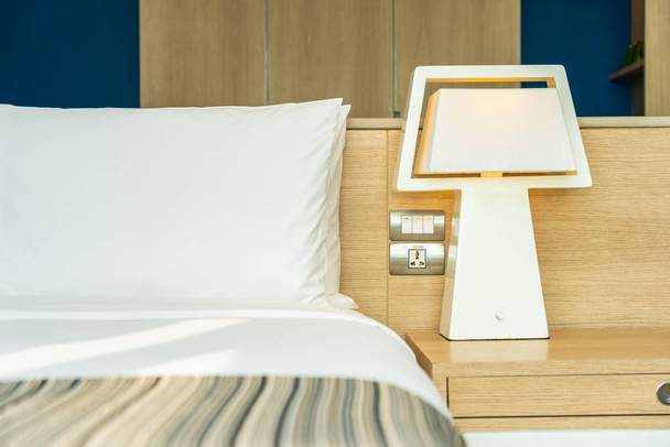 Almohada y manta en la cama con lámpara de luz decoración interior
 - Foto, Imagen