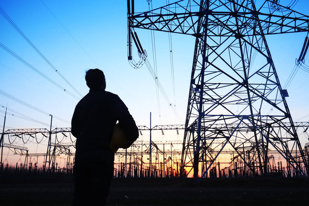 Stromarbeiter und Pylon-Silhouette - Foto, Bild
