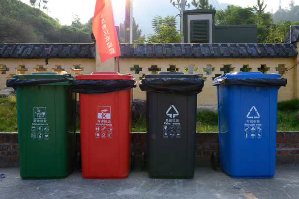 Xinxing, Guangdong, Κίνα-2 Οκτωβρίου 2019: διαφορετικοί κάδοι απορριμμάτων χρωμάτων για διαλογή απορριμμάτων, δηλαδή. μαγειρείων, επιβλαβών, άλλων και ανακυκλώσιμων αποβλήτων. - Φωτογραφία, εικόνα