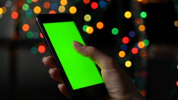 Frau hält Smartphone mit grünem Bildschirm und blättert. Hand mit Handy in Nahaufnahme - Filmmaterial, Video