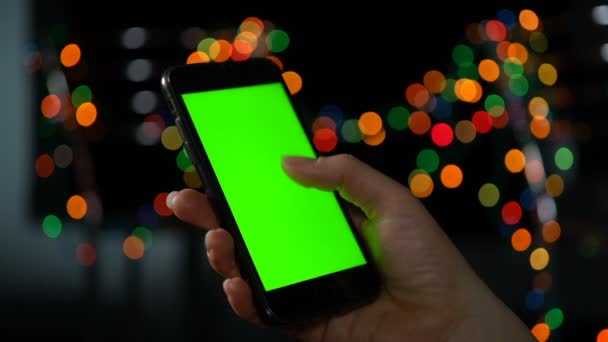 Close-up van een smartphone met een groen scherm. Schuiven op het scherm. - Video