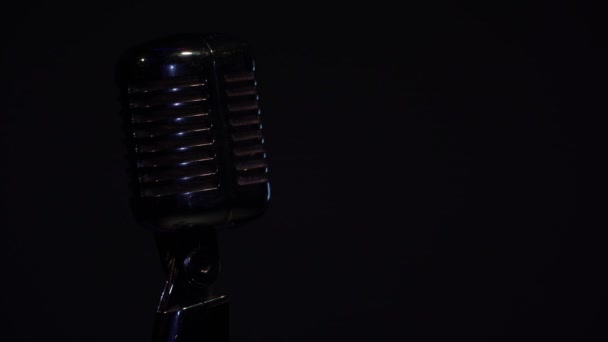 Το φως σβήνει. Επαγγελματική συναυλία vintage glare μικρόφωνο για εγγραφή ή να μιλήσετε με το κοινό στη σκηνή σε σκοτεινό άδειο ρετρό club από κοντά. Spotlight σβήνει σε μαύρο φόντο.  - Πλάνα, βίντεο