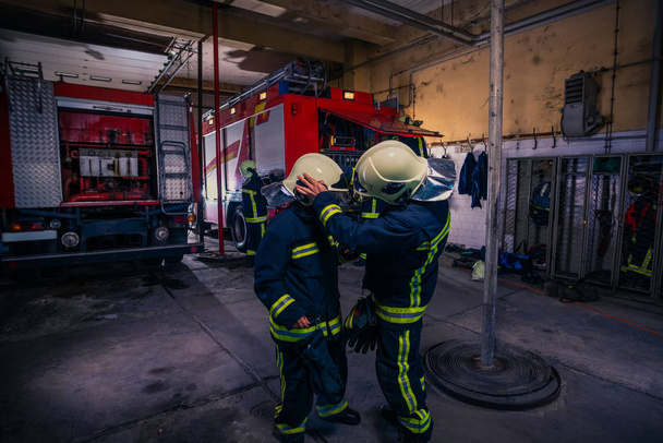 Brandweerlieden bereiden hun uniform en de brandweerwagen in de ba voor - Foto, afbeelding