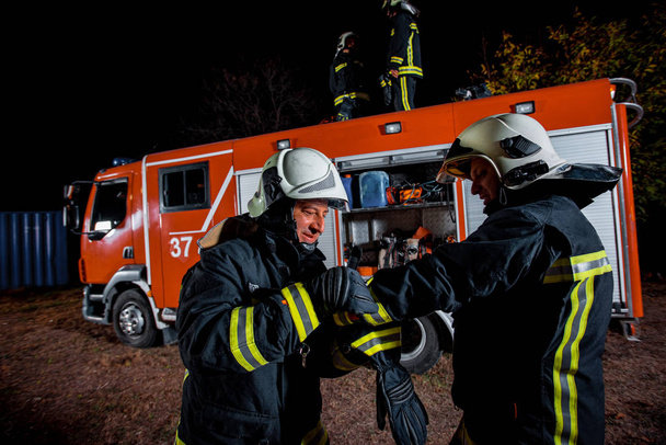Bomberos que preparan el equipo de bomberos para apagar las llamas - Foto, imagen