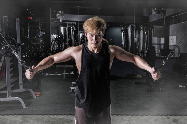 Erős fitness férfi csinál kar edzés kábeles gép a g - Fotó, kép