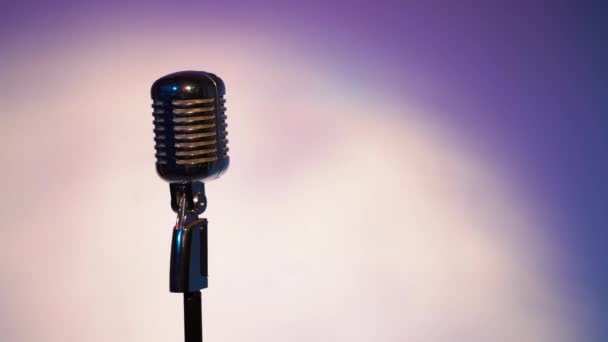 Microphone vintage argenté professionnel éblouissant pour enregistrement ou parler au public sur scène dans un club rétro sombre vide fermer. Les projecteurs brillent sur un micro chromé avec des reflets sur fond fantastique de l'espace
. - Séquence, vidéo